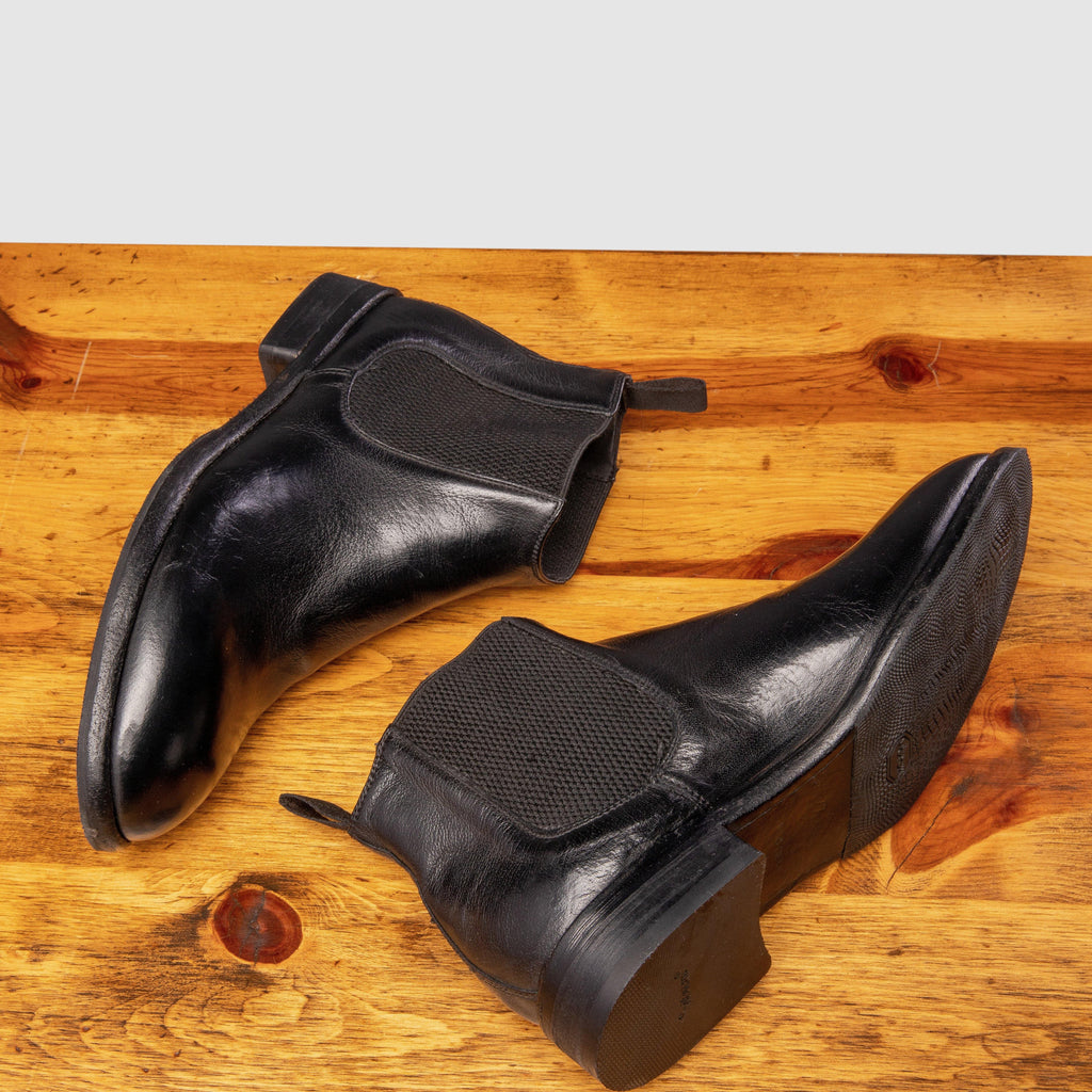 Pair of D367 Calzoleria Toscana Women's Black Chelsea Boot laying down showing the side profile on top of a wooden table