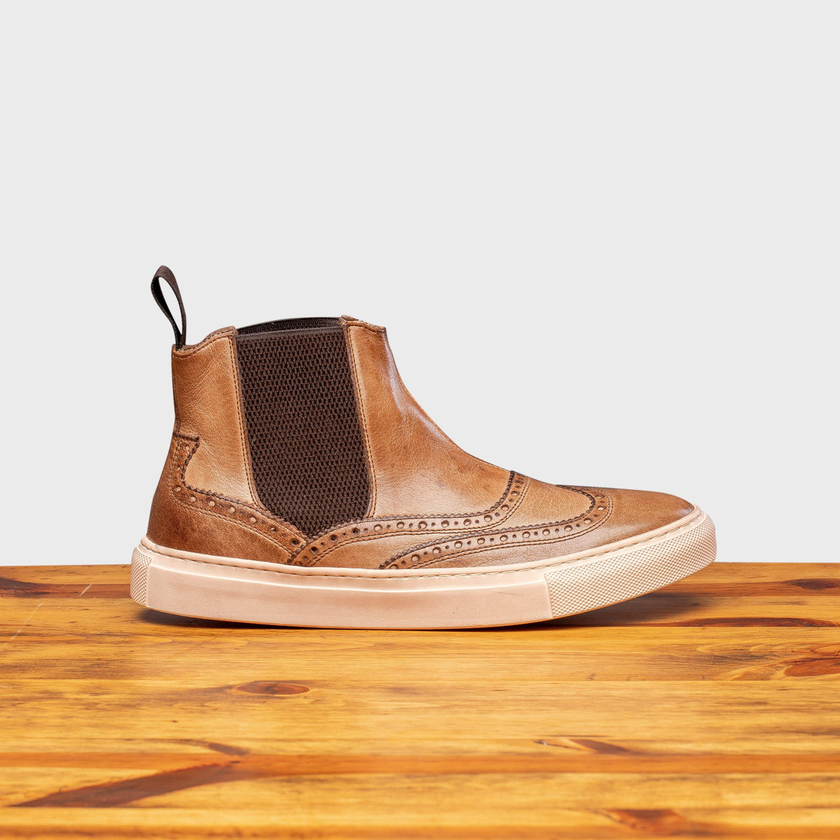 Moor leather shoe on a wooden surface with a light gray background