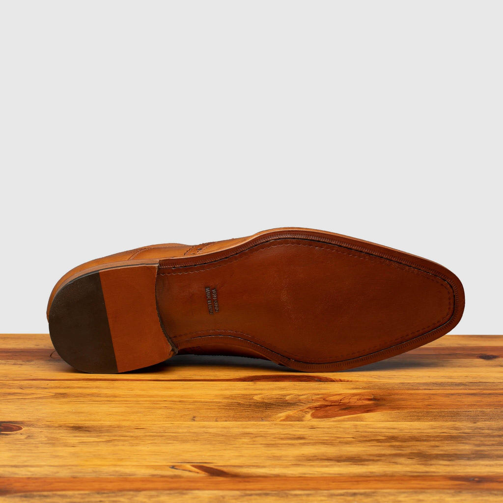 Full leather outsole of H310 Calzoleria Toscana Chester Onice Wingtip Balmoral on top of a wooden table