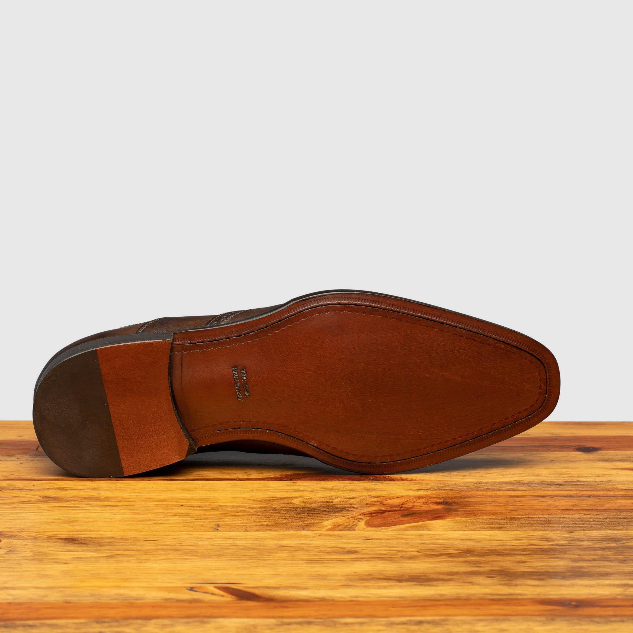 Full leather outsole of H310 Calzoleria Toscana Fondant Onice Wingtip Balmoral on top of a wooden table