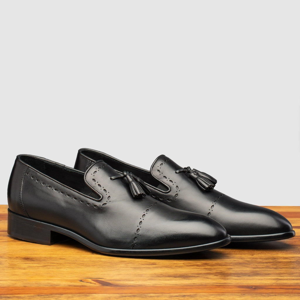 Profile of H614 Calzoleria Toscana Black Tassel Slip-On on top of a wooden table