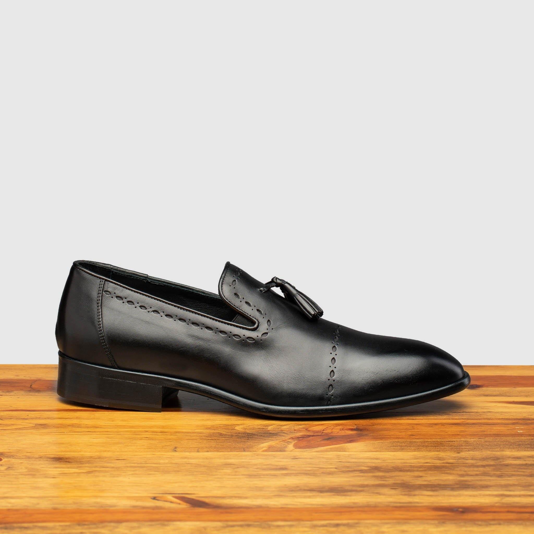 Side profile of H614 Calzolera Toscana Black Tassel Slip-On on top of a wooden table