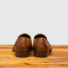 Back profile of H614 Calzoleria Toscana Chestnut Tassel Slip-On on top of a wooden table