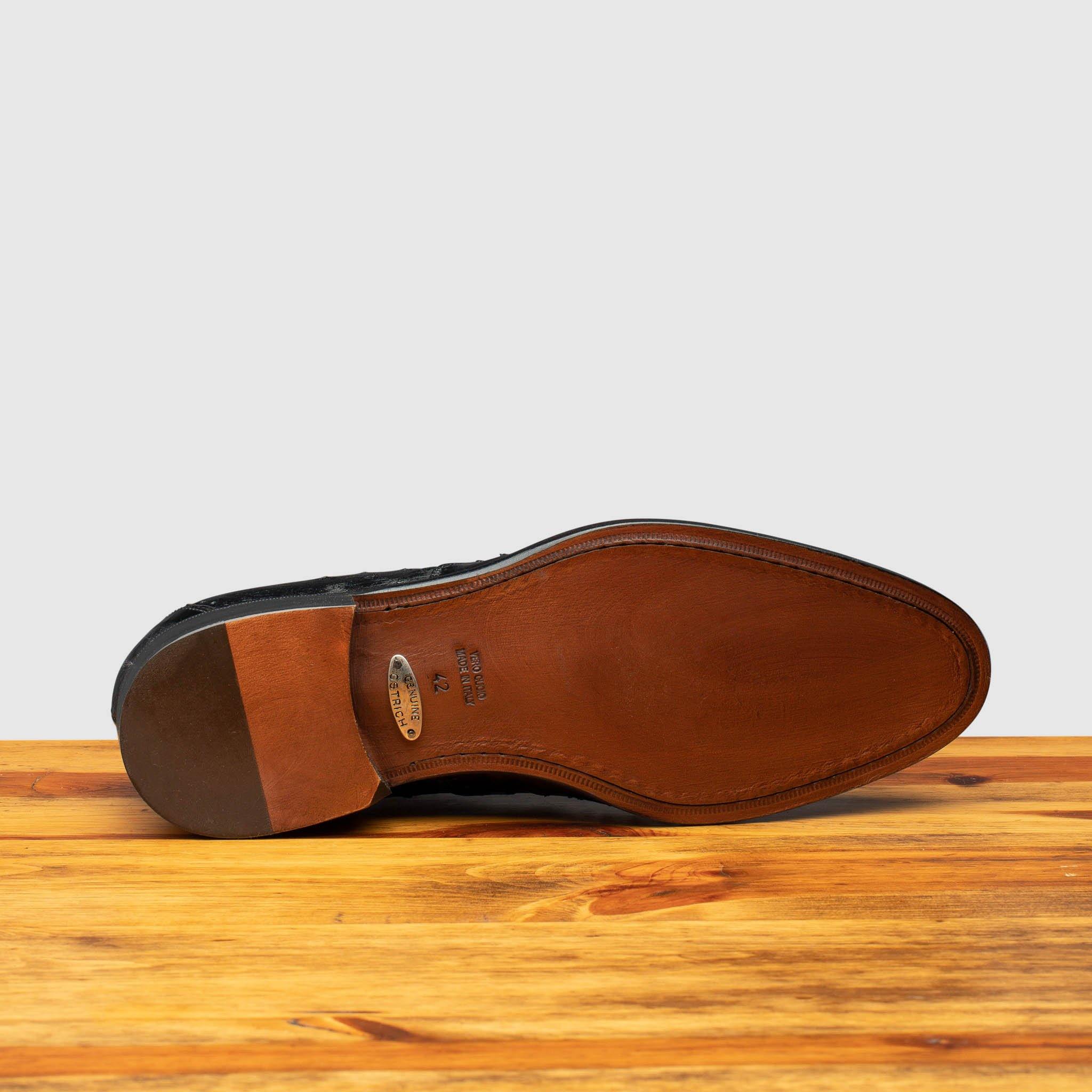 Full leather outsole of H777 Calzoleria Toscana Black Ostrich Cap Toe on top of a wooden table