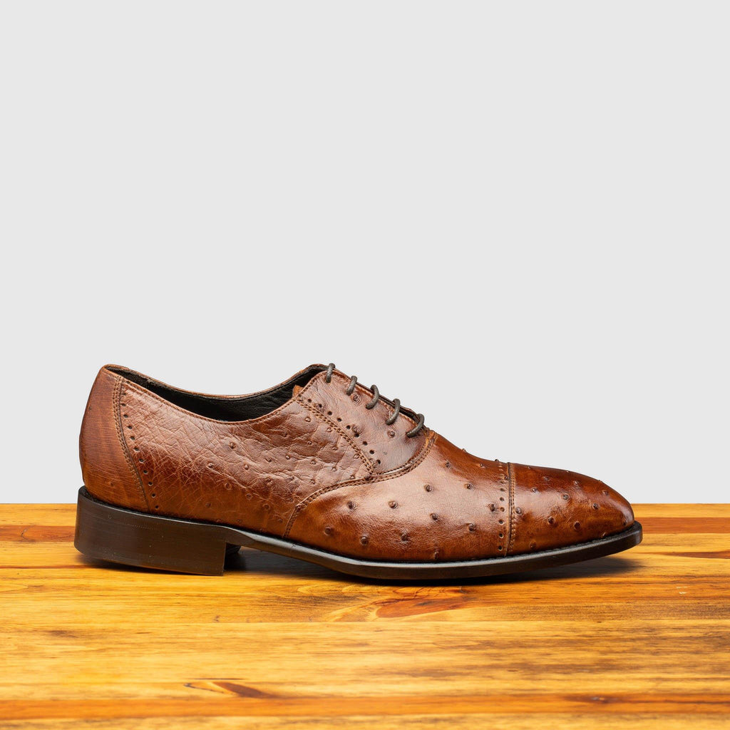 Side profile of H777 Calzoleria Toscana Cognac Ostrich Cap Toe on top of a wooden table