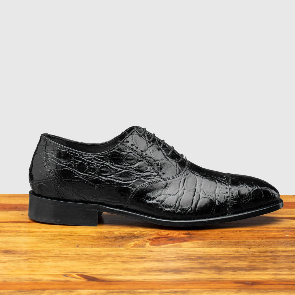 Side profile of H779 Calzoleria Toscana Black Silver Flanks Cap Toe on top of a wooden table