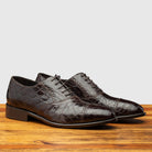 Pair of H779 Calzoleria Toscana Chocolate Silver Flanks Cap Toe on top of a wooden table