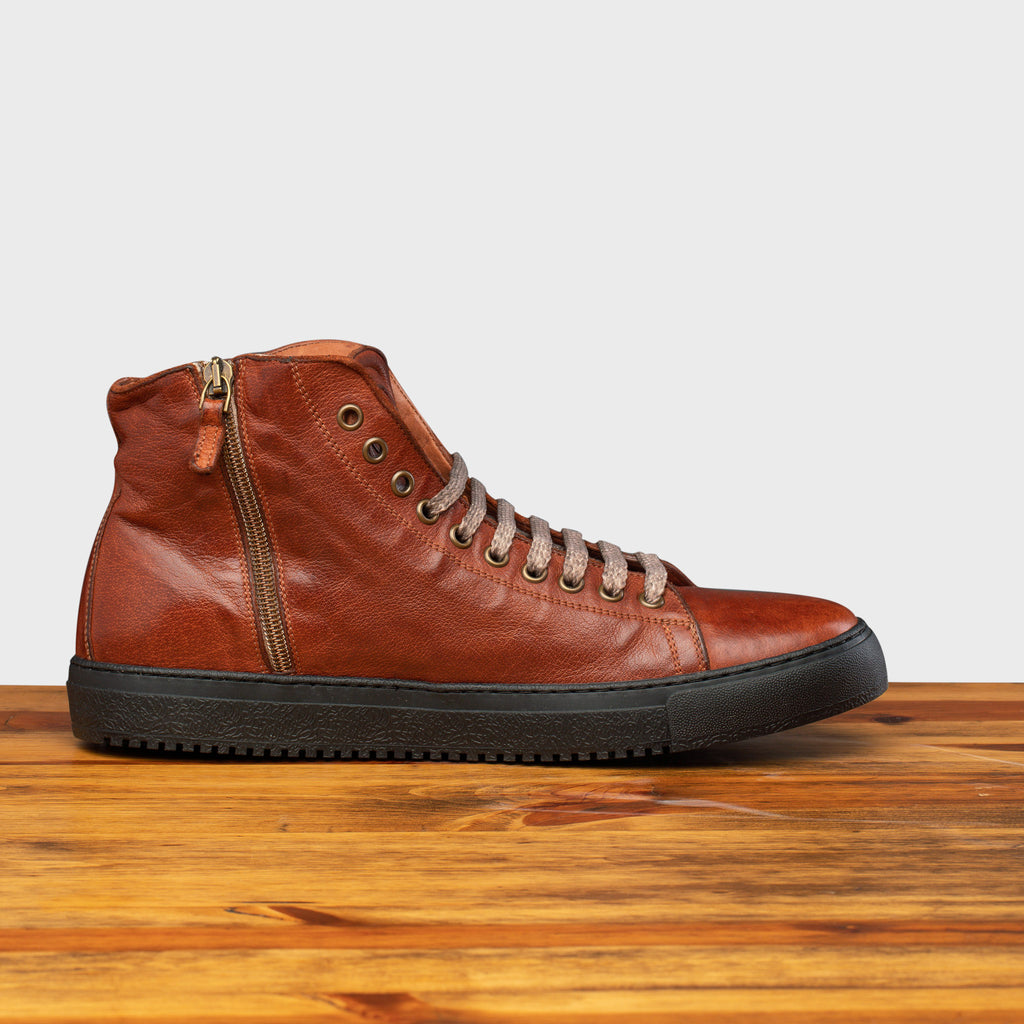 Side profile showing the functional inside zipper of H883 Calzoleria Toscana High Top Benso Sneaker on top of a wooden table