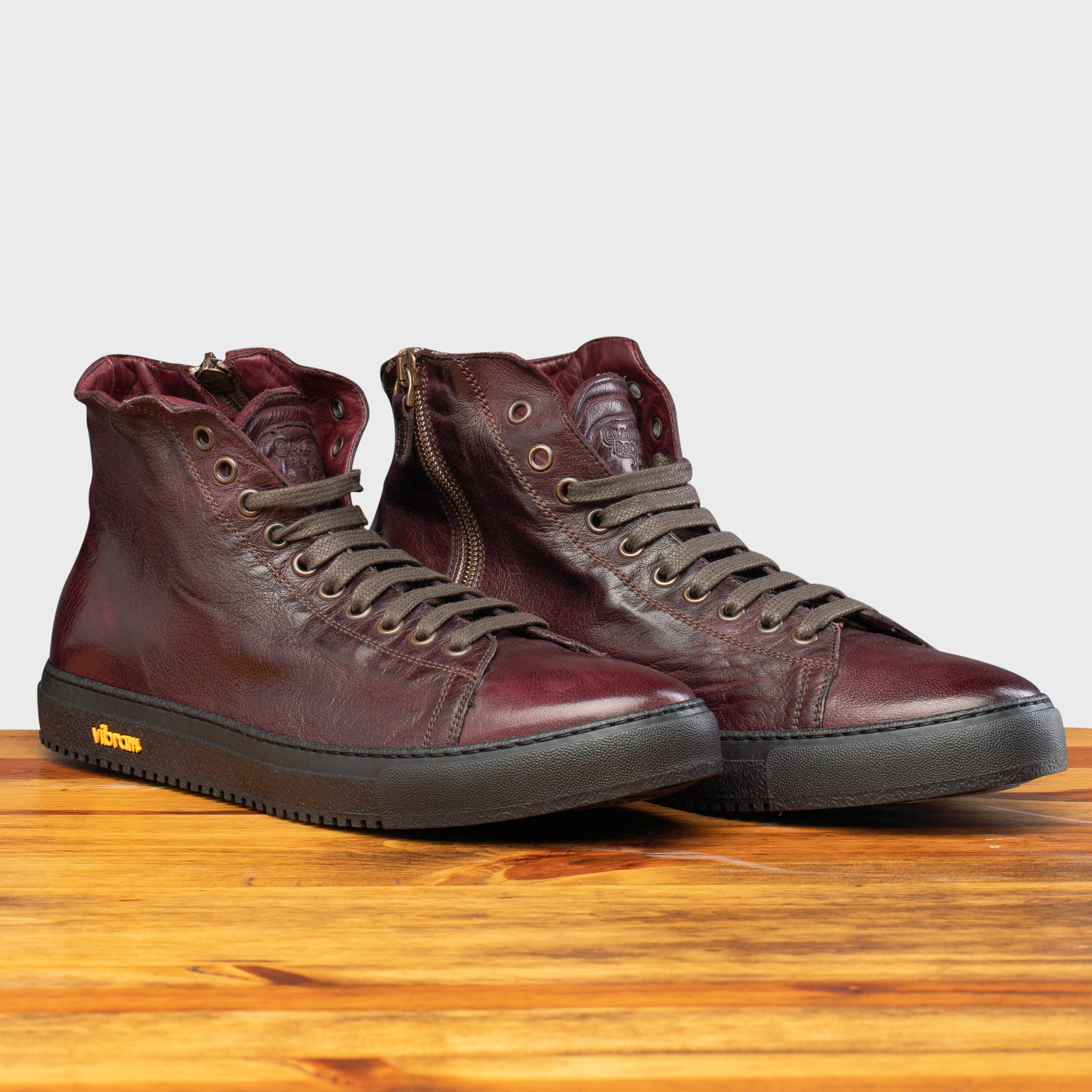 Side profile of H883 Calzoleria Toscana Liver High Top Benso Sneaker on top of a wooden table