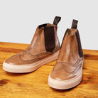 Pair of Moor leather shoe on a wooden surface with a light gray background