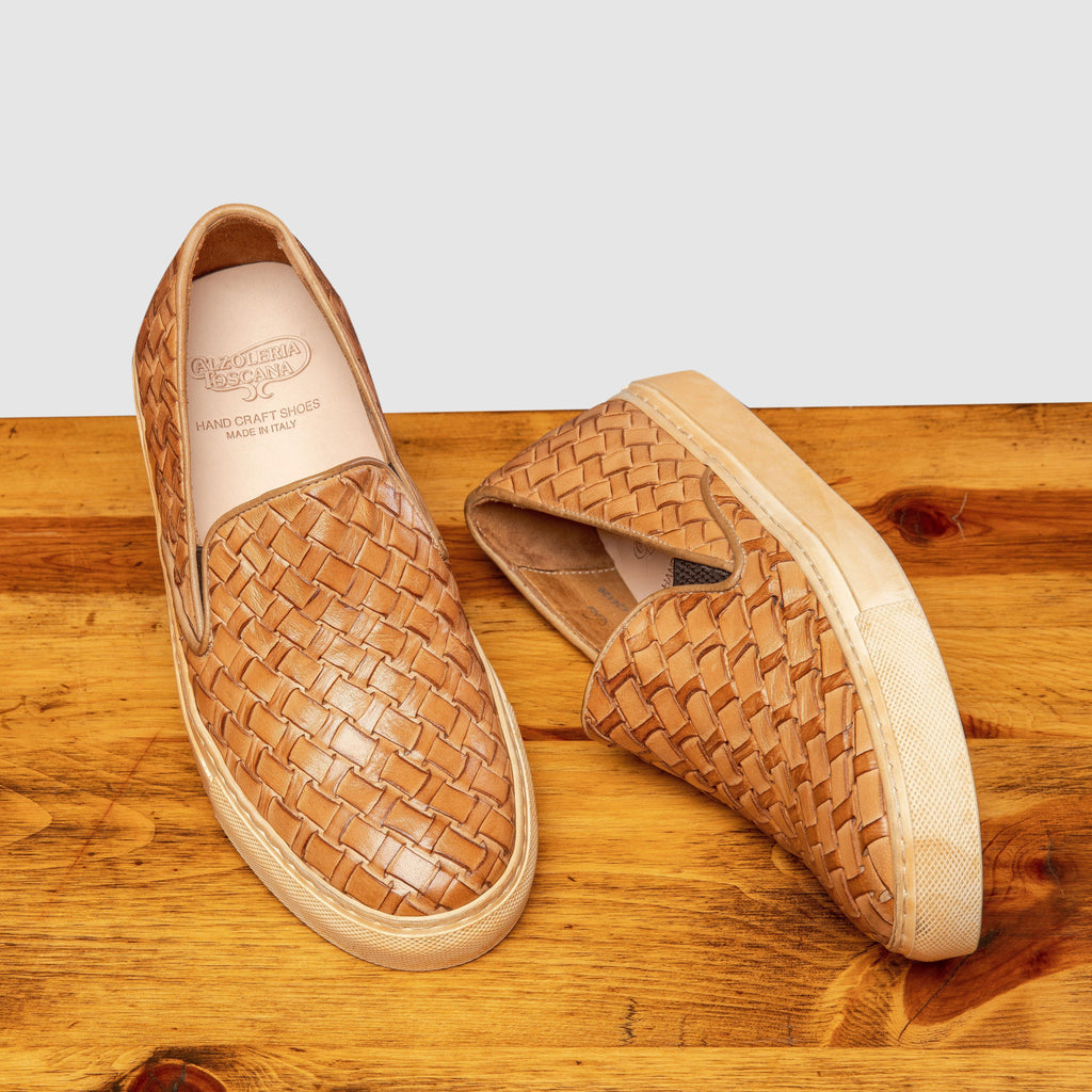 Pair of 9576 Calzoleria Toscana Women's Brick Dip-Dyed Woven Sneaker showing the brand name label on top of a wooden table