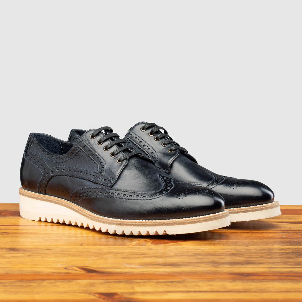 Pair of the Q399 Calzoleria Toscana Blue Agos Wingtip Blucher on top of a wooden table