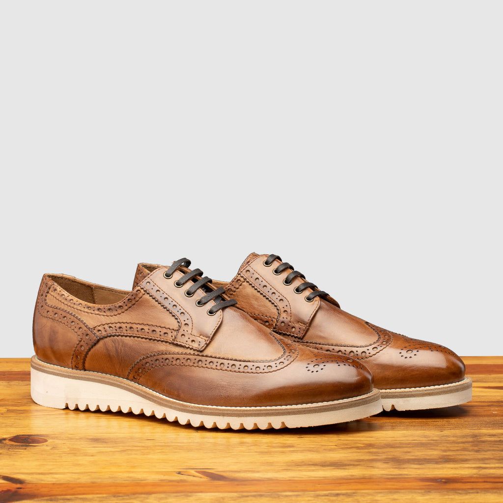 Pair of Q399 Calzoleria Toscana Cerris Agos Wingtip Blucher on top of a wooden table