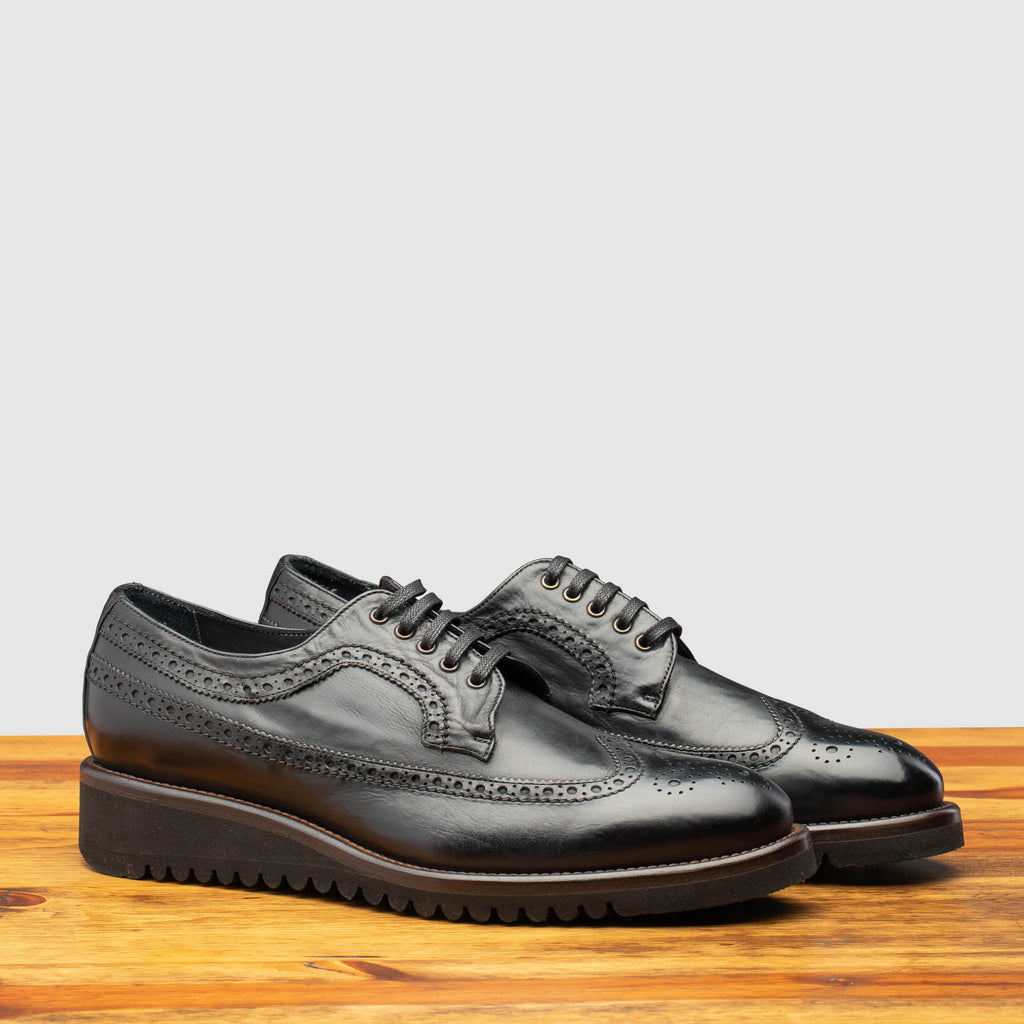 Pair of Q400 Calzoleria Toscana Black Agos Blucher on top of a wooden table