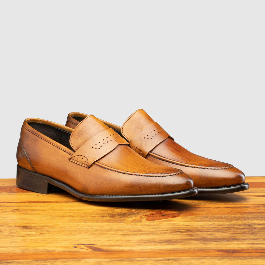 Pair of Q540 Calzoleria Toscana Chestnut Wholecut Slip-On on top of a wooden table