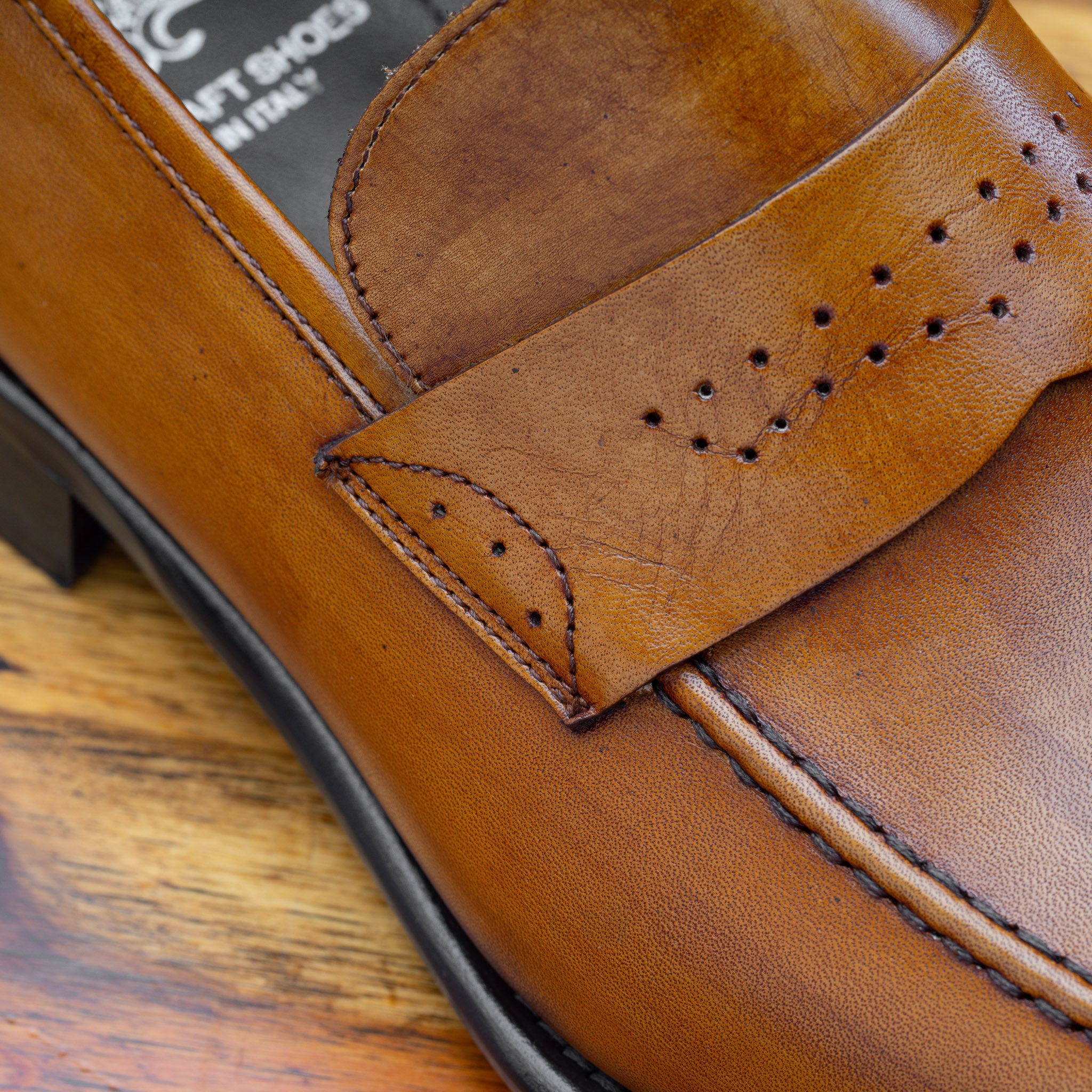 Up close photo of the penny strap with perforated details on Q540 Calzoleria Toscana Chestnut Wholecut Slip-On