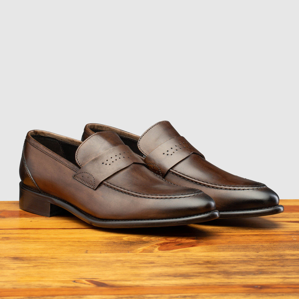Pair of Q540 Calzoleria Toscana Moor Wholecut Slip-On on top of a wooden table