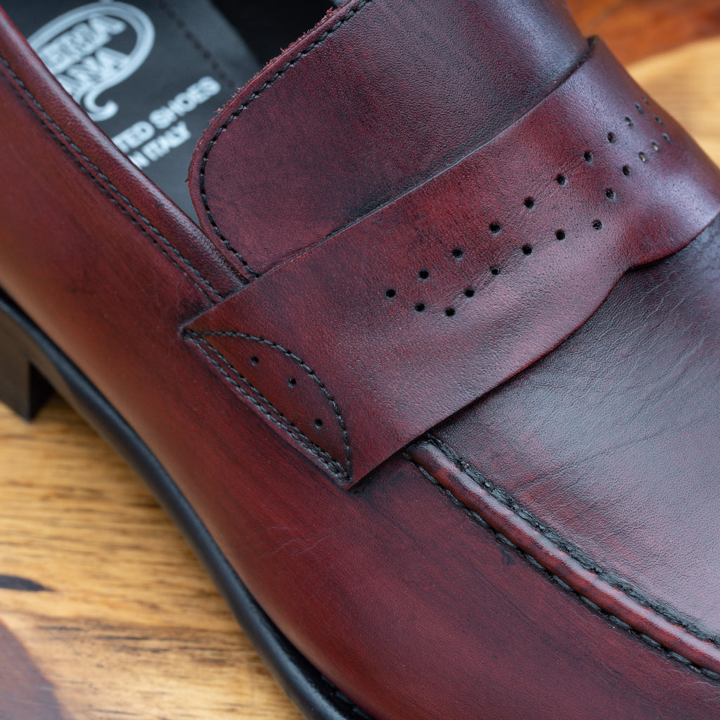 Up close photo of the penny strap with perforated details on Q540 Calzoleria Toscana Burgundy (Porpora) Wholecut Slip-On