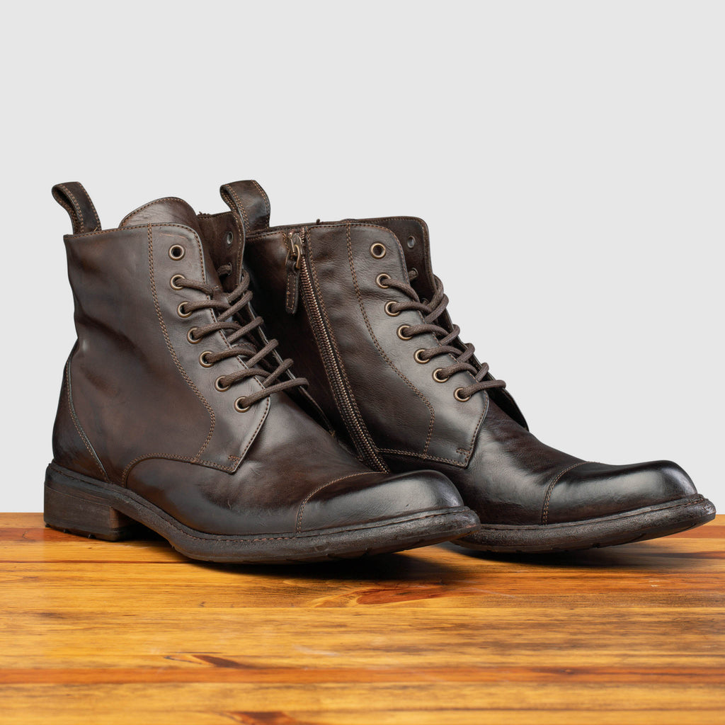 Pair of Q549 Calzoleria Toscana Dark Brown Combat Boot on top of a wooden table