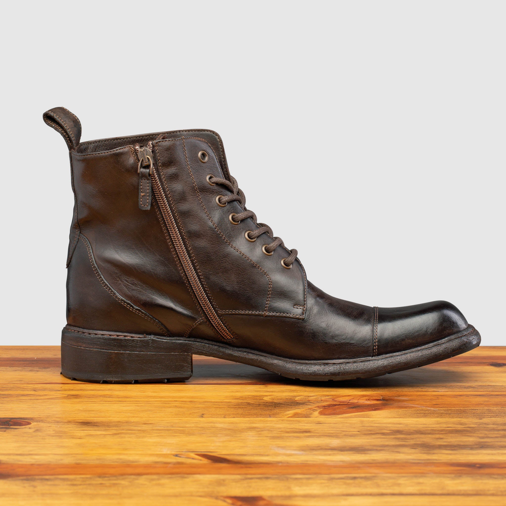 Side profile of Q549 Calzoleria Toscana Dark Brown Combat Boot on top of a wooden table