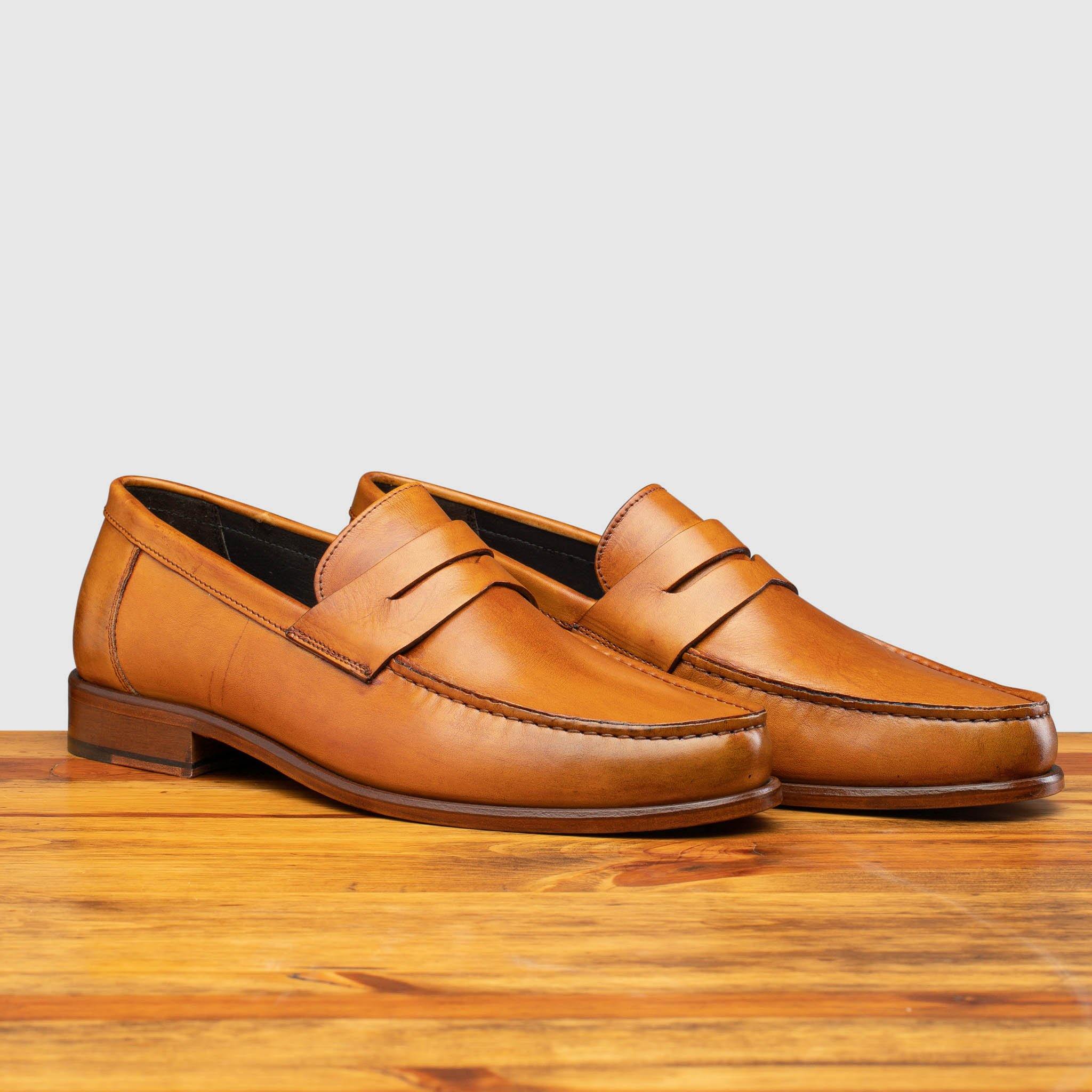Pair of Calzoleria Toscana Santor Collegiate Loafer in Dark Caramel on top of a wooden table