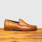 Side profile of Calzoleria Toscana Santor Collegiate Loafer in Dark Caramel on top of a wooden table