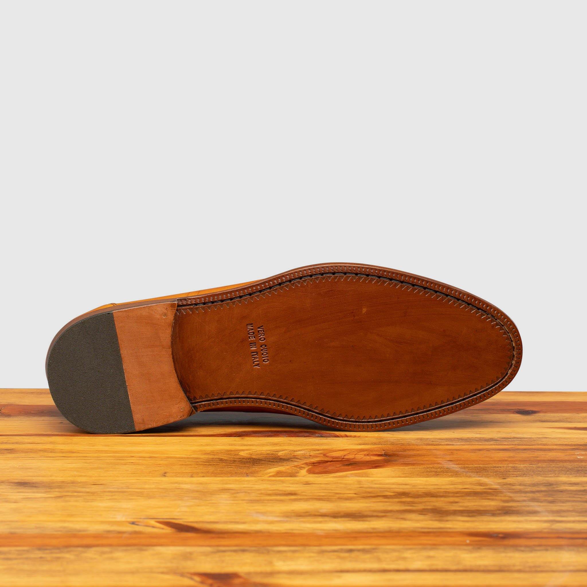 Full leather outsole of Calzoleria Toscana Santor Collegiate Loafer in Dark Caramel on top of a wooden table
