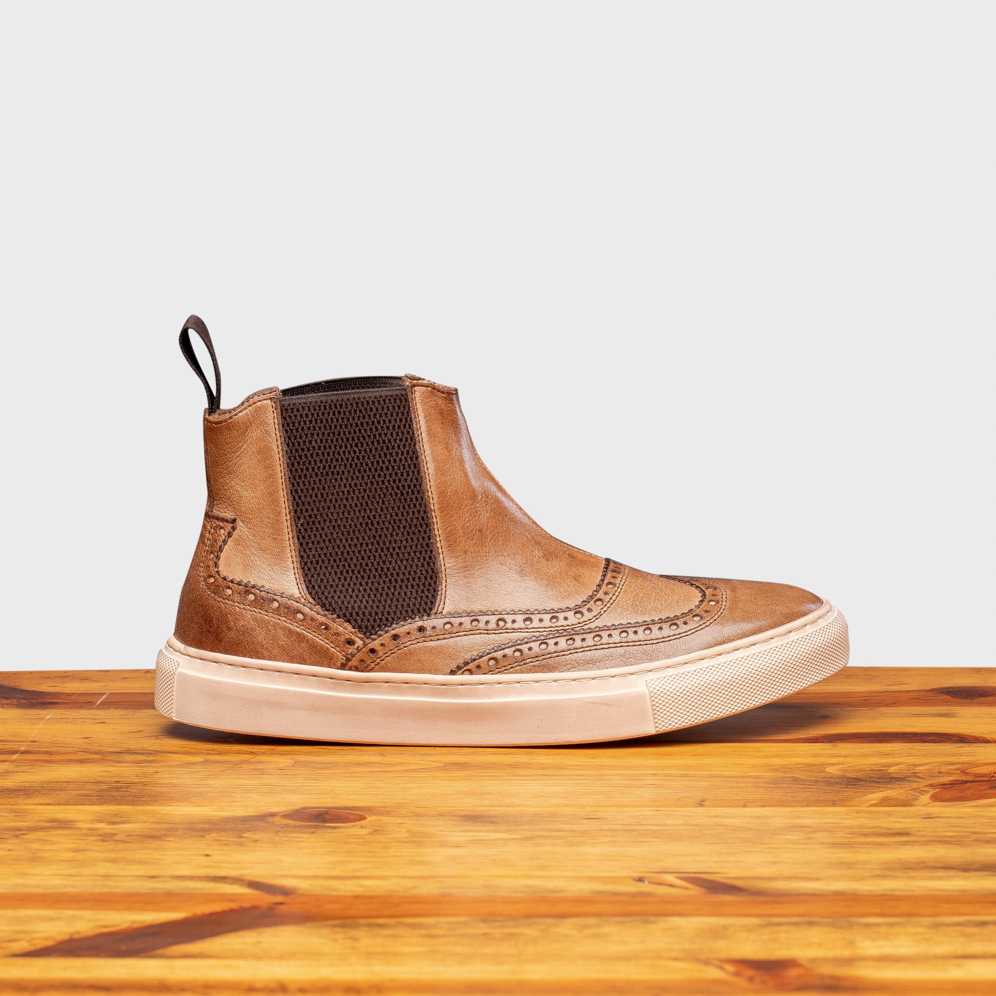 Side profile showing brown contrasting color of the side gore of D741 Calzoleria Toscana Ankle Sneaker on top of a wooden table