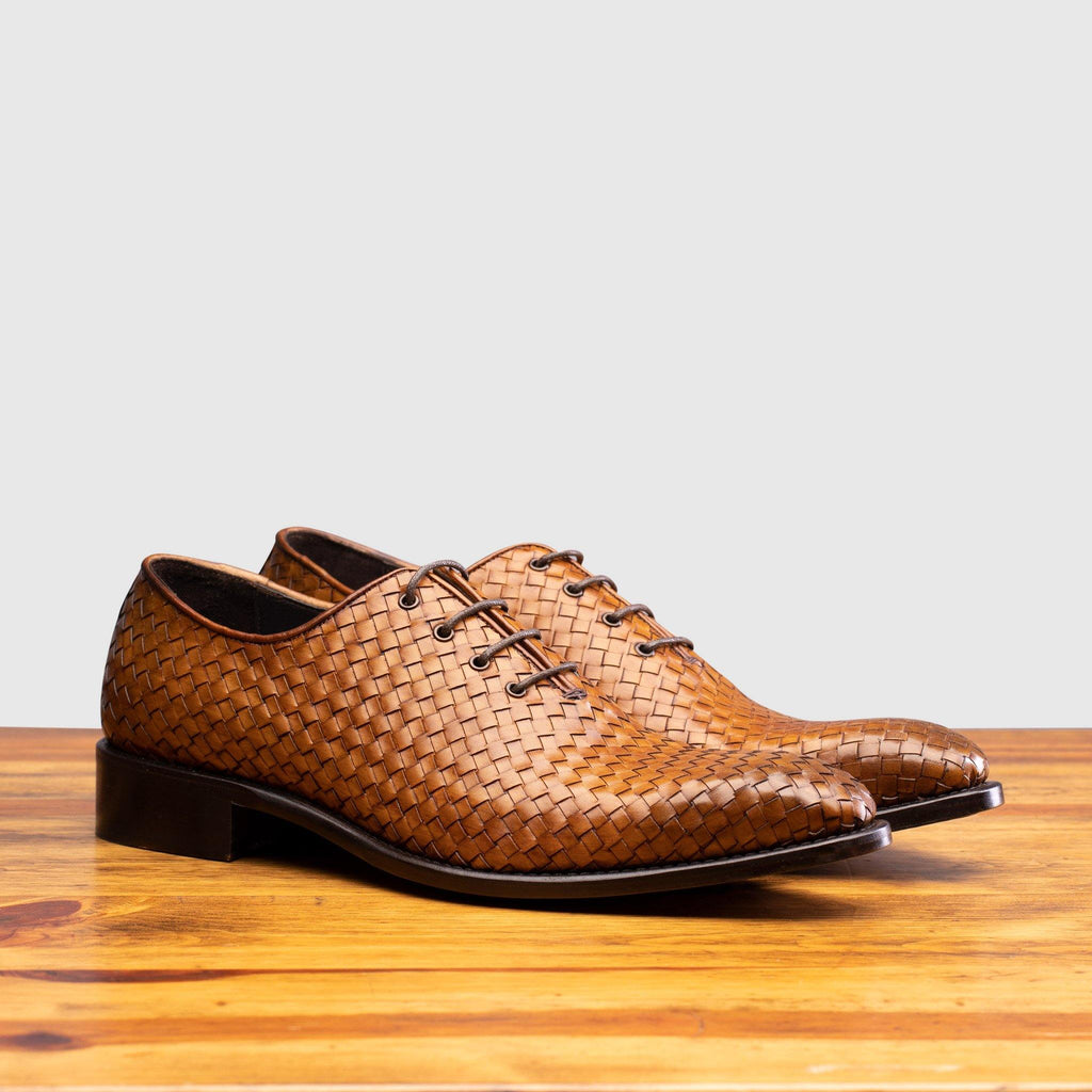 Pair of 5373 Calzoleria Toscana Chestnut Woven Lace-up on top of  a wooden table