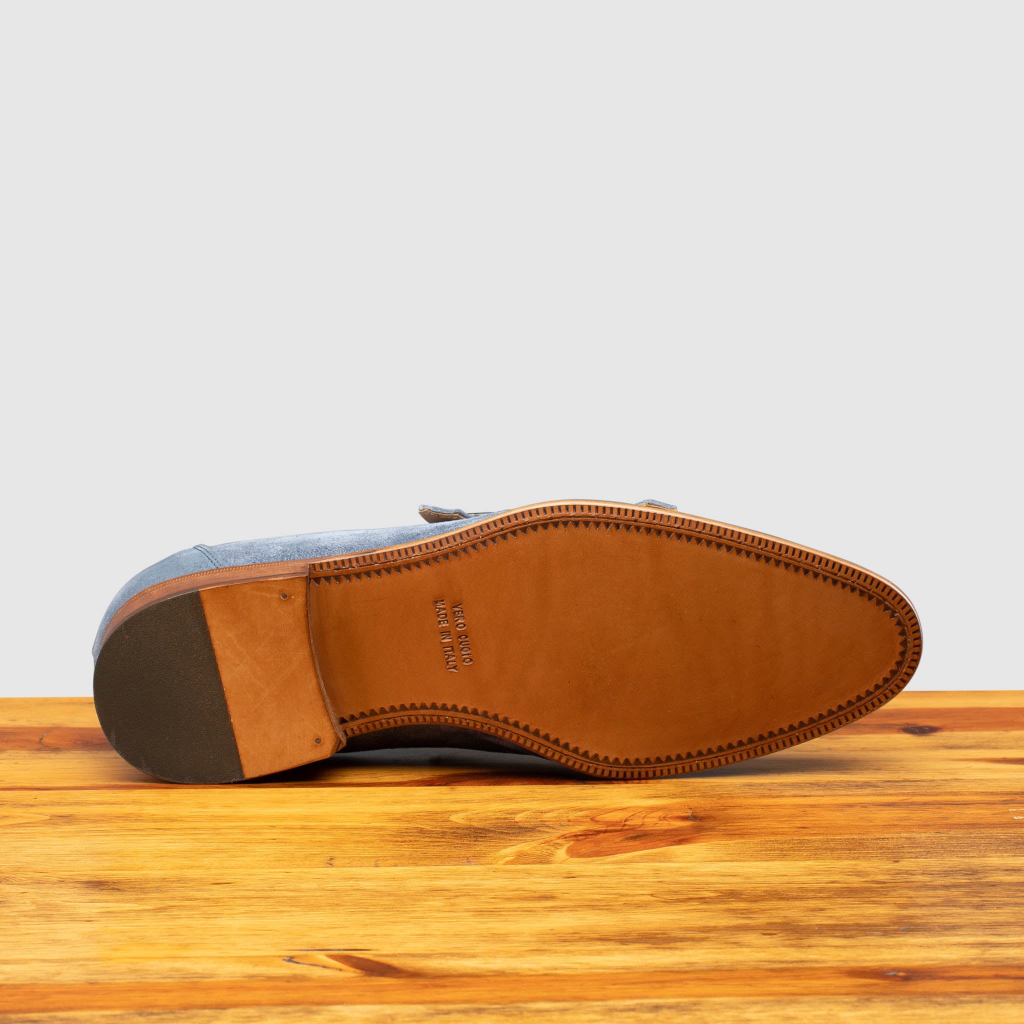 Full leather outsole of Z893 Calzoleria Toscana Jean Blue Double Strap Low Vamp Slip-On on top of a wooden table
