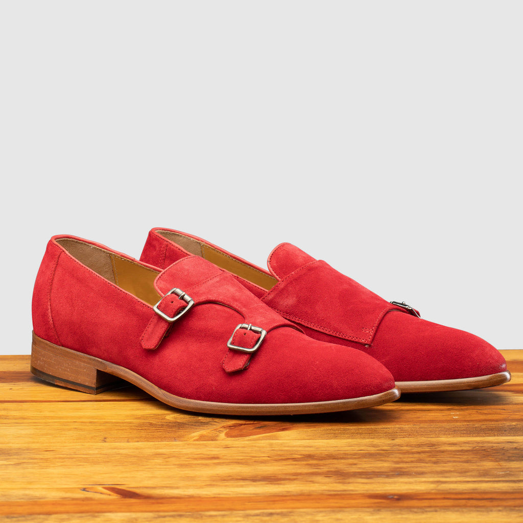 Pair of Z893 Calzoleria Toscana Red Suede Double Strap Low Vamp Slip-On on top of a wooden table