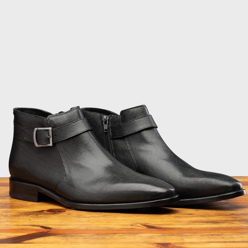 Pair of the 1221 Calzoleria Toscana Saffiano Leather Black Ankle Zip Boot on top of a wooden table